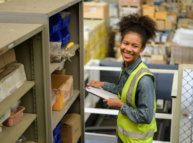 Female warehouse worker Counting items in an industrial warehouse